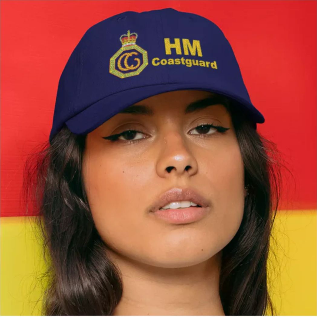 Person wearing a blue HM Coastguard cap against a red and yellow background