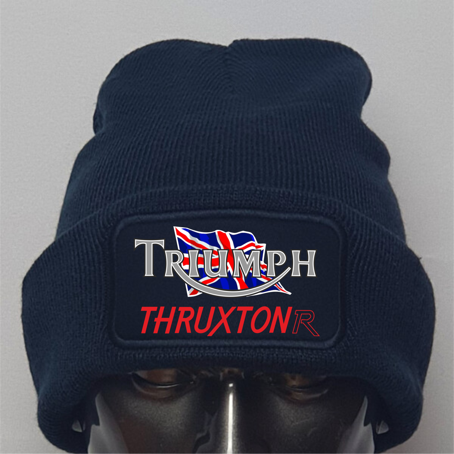 Navy blue beanie with Triumph Thruxton logo on a gray background