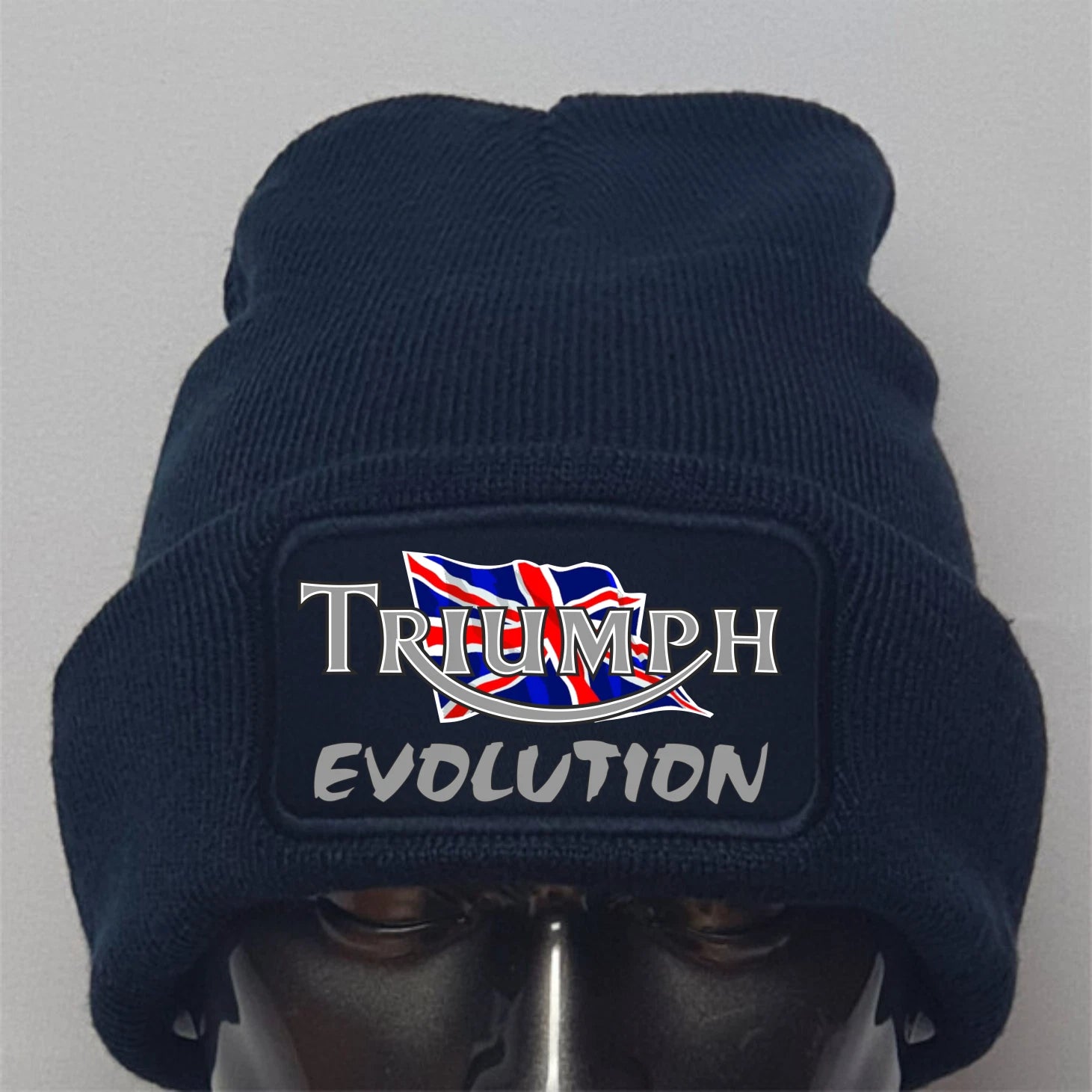 Navy blue beanie with 'Triumph Evolution' logo on a gray background