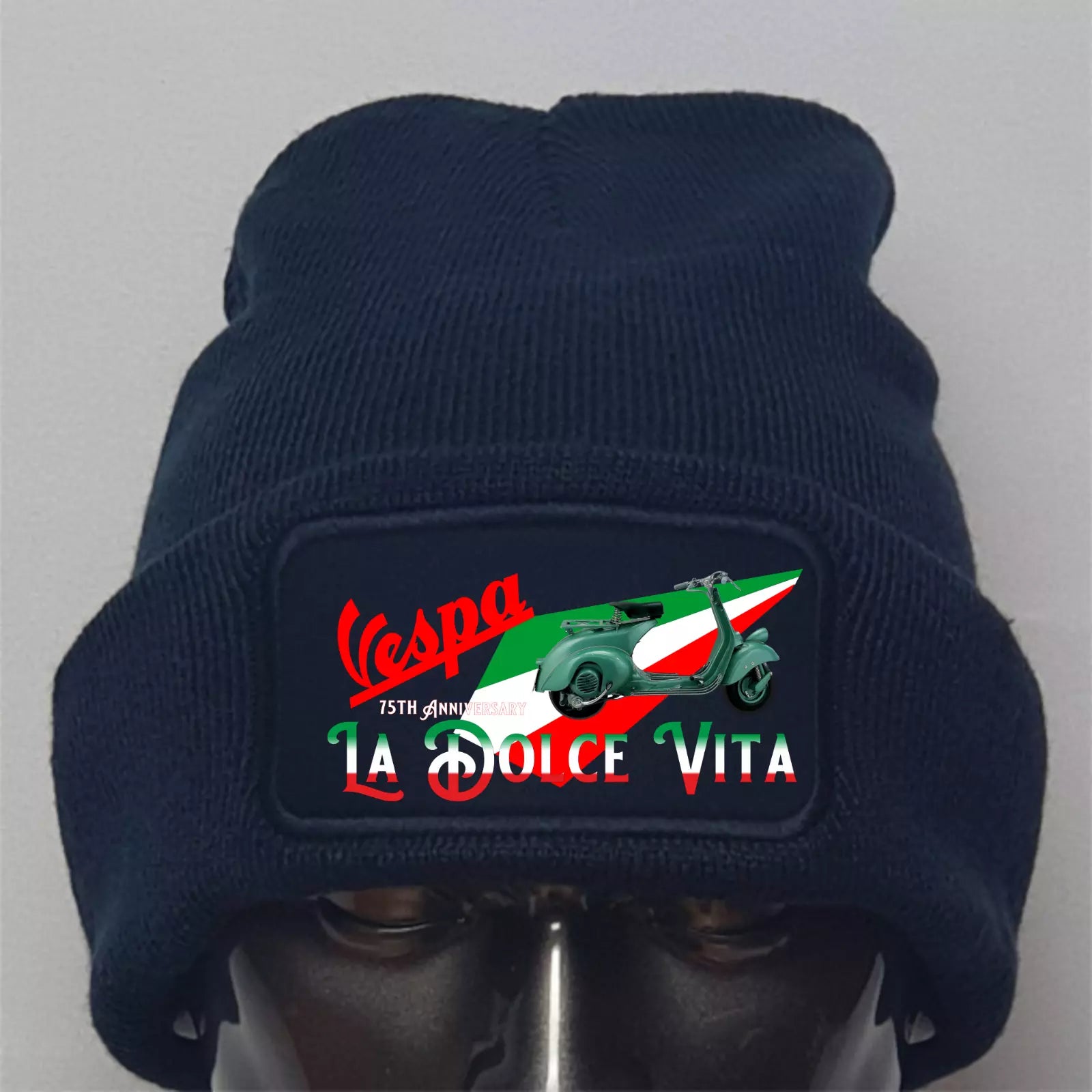 Navy blue beanie with Vespa logo and text on a gray background