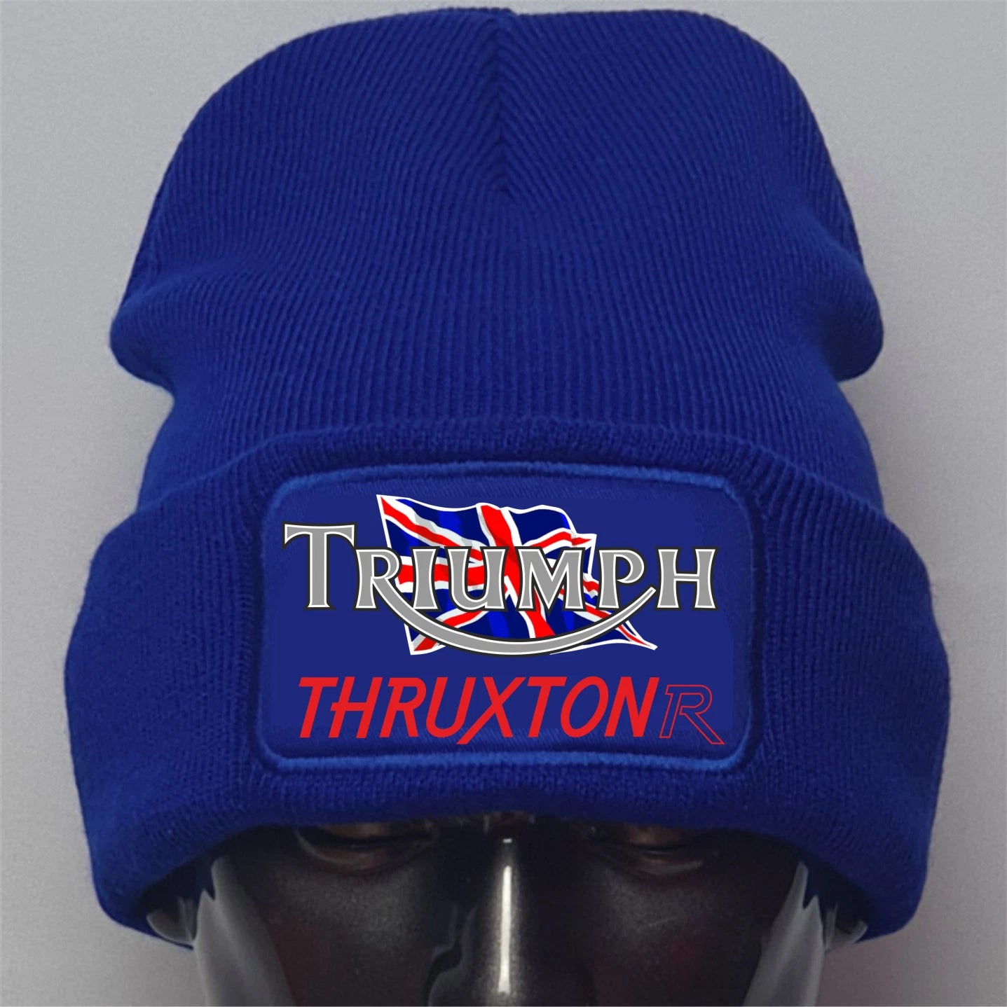 Blue beanie with Triumph Thruxton logo on a gray background