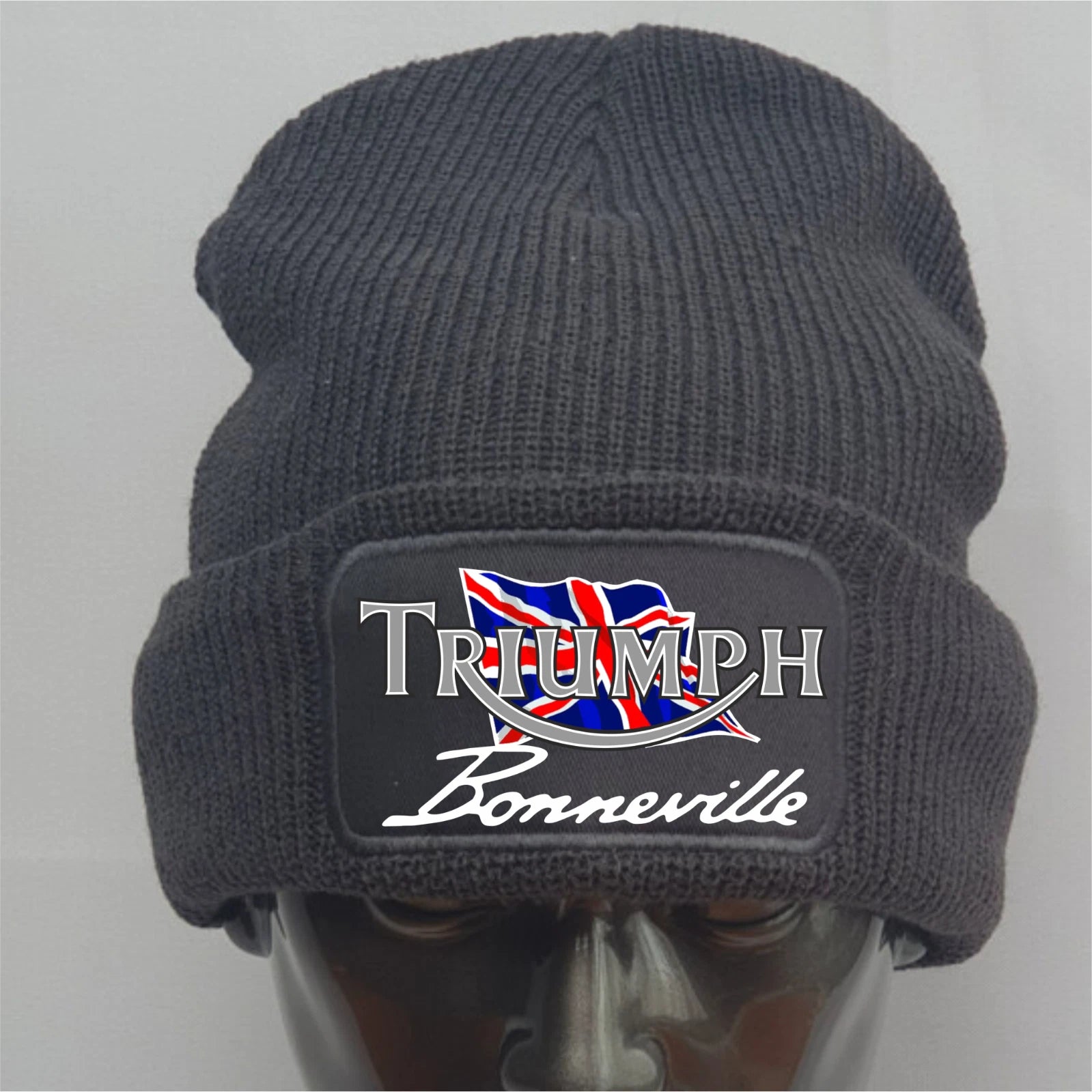 Dark gray knit beanie with Triumph Bonneville logo on a mannequin head against a light gray background