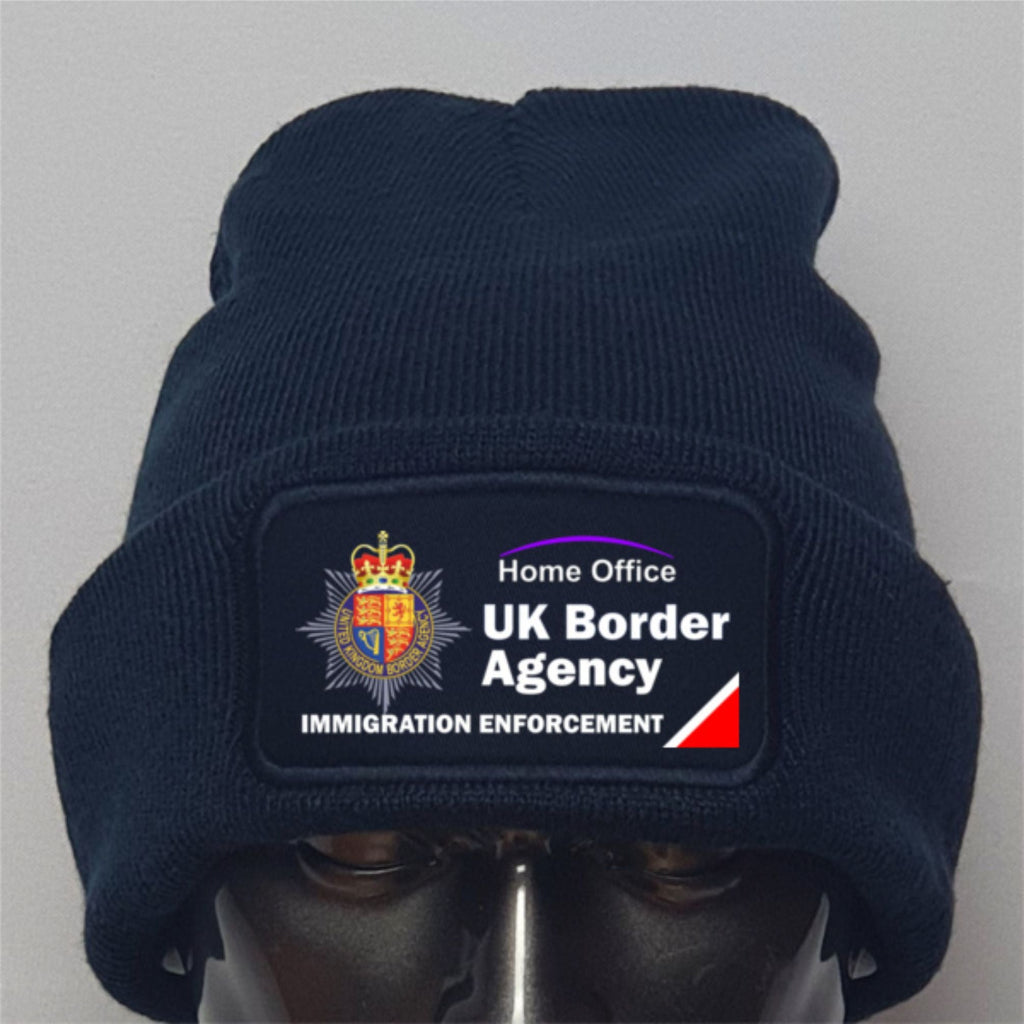 Navy beanie with UK Border Agency logo on a gray background