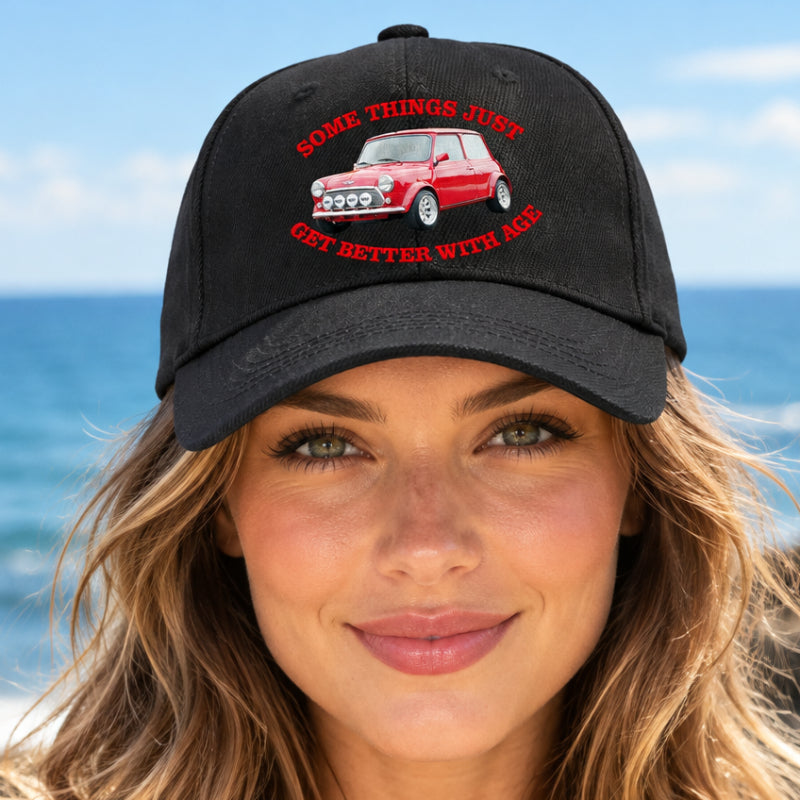 A black baseball cap featuring a red vintage Mini Cooper graphic with the text 'SOME THINGS JUST GET BETTER WITH AGE' in red on the front panel.