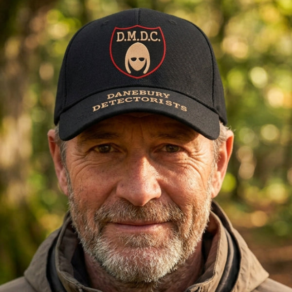 A black baseball cap featuring a front shield patch with the text 'D.M.D.C.' referring to the BBC comedy series The Detectorsts.