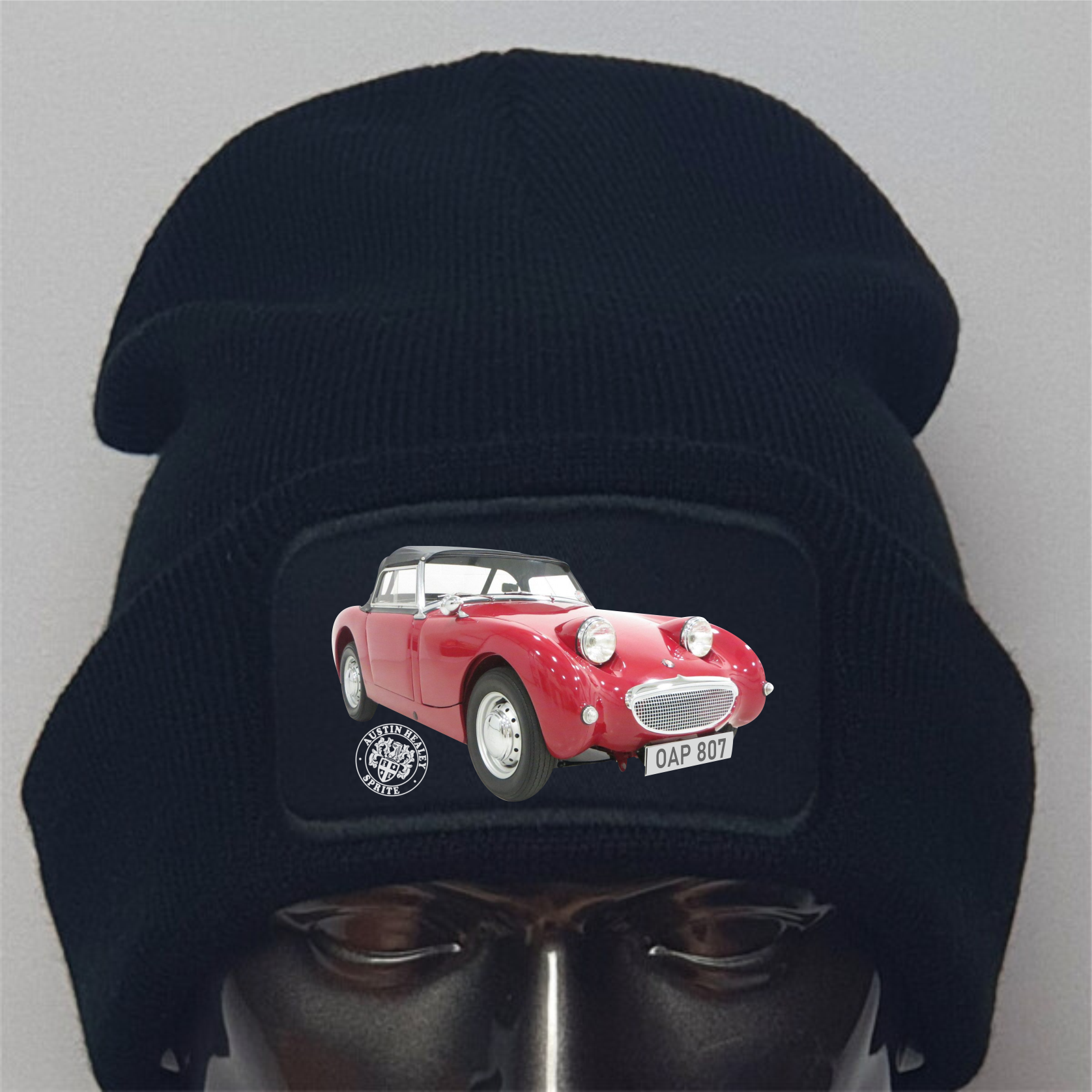 Black beanie with a red vintage car design on a gray background