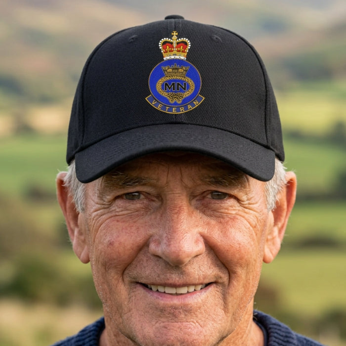 A black baseball cap featuring a detailed printed British Merchant Navy Veteran crest on the front, set against a plain white background.