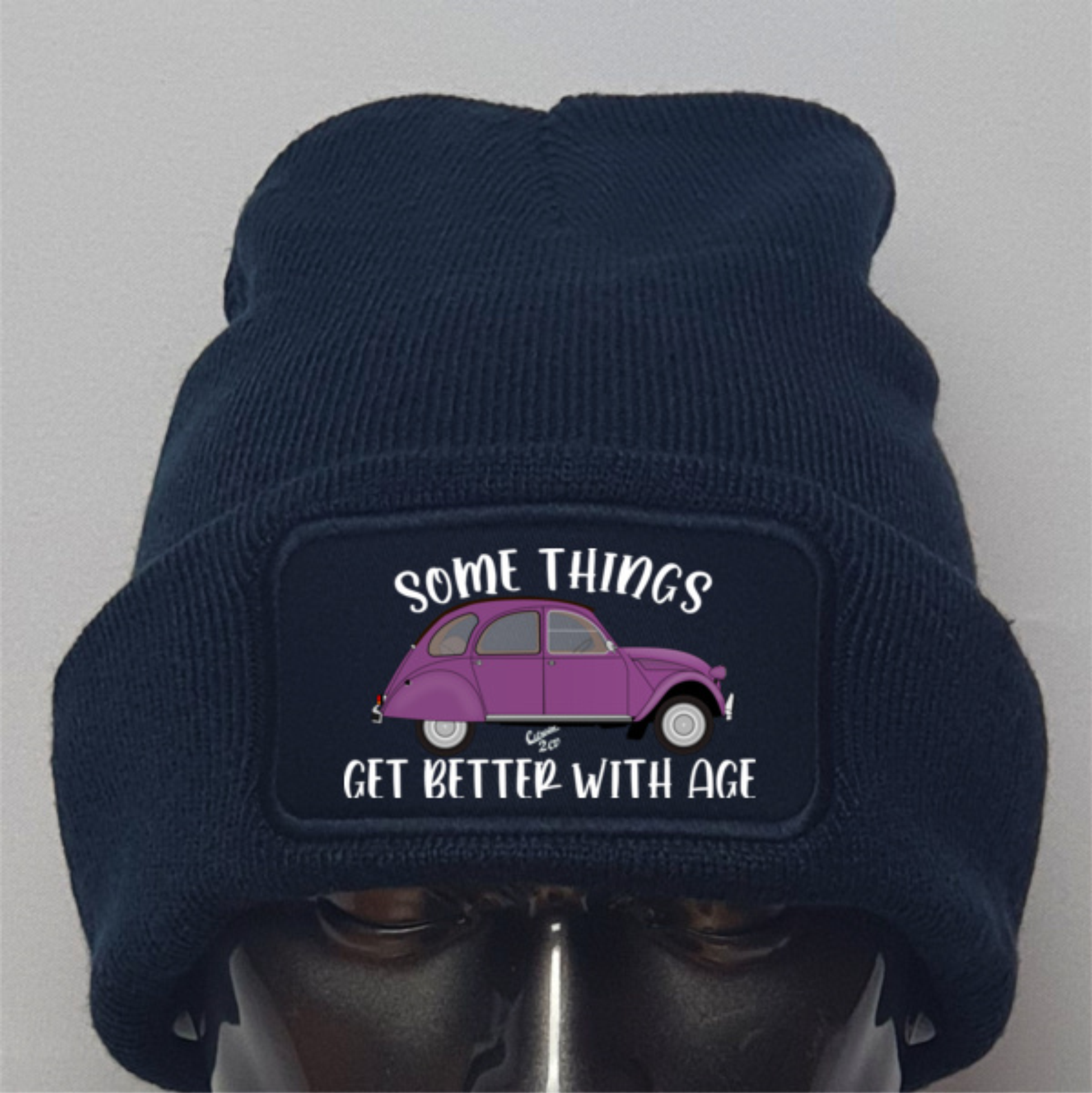 Navy blue beanie with a purple car graphic and text on a gray background