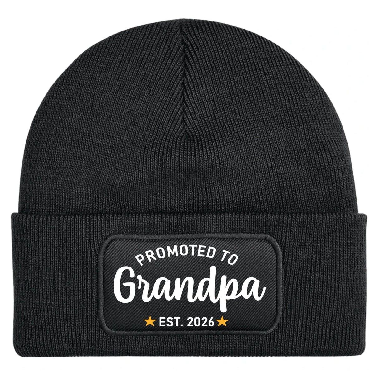 A black ribbed knit beanie hat with a folded cuff, featuring a rectangular black patch on the front with white text reading 'PROMOTED TO Grandpa' and 'EST. 2026' with small gold stars.