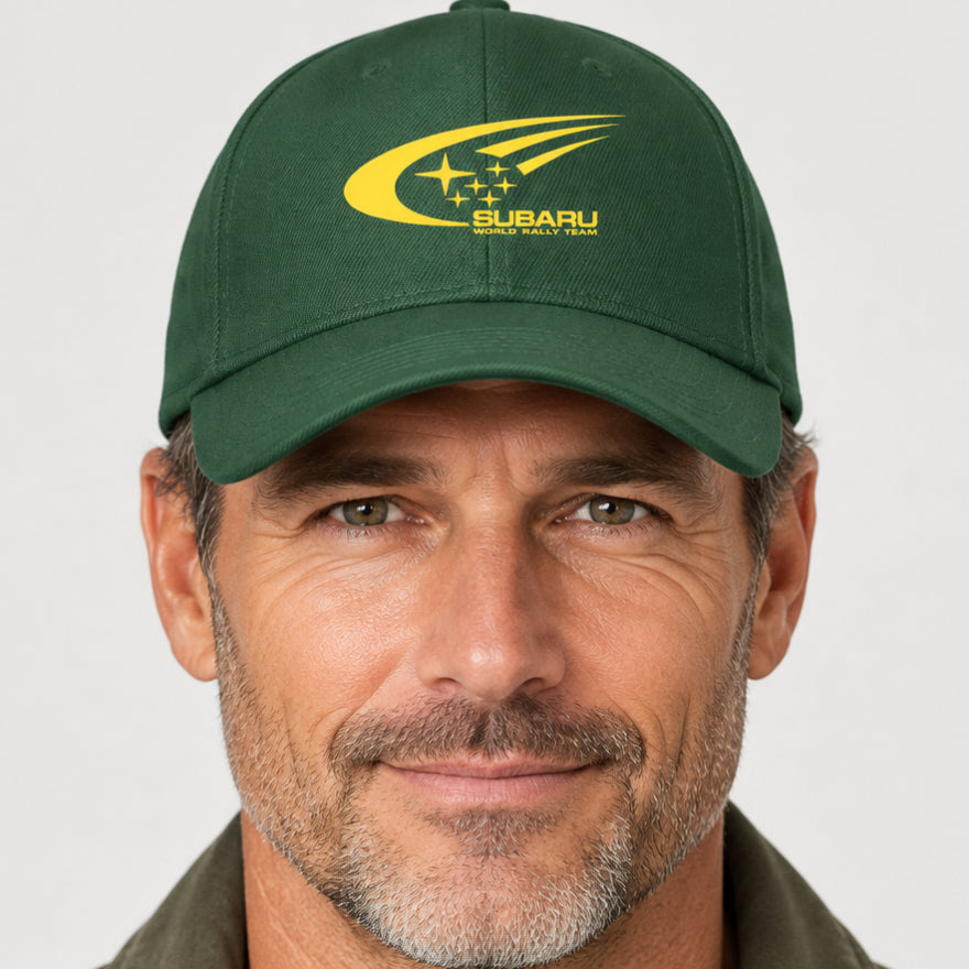 A dark green baseball cap featuring a yellow printed Subaru World Rally Team logo on the front, set against a plain white background.