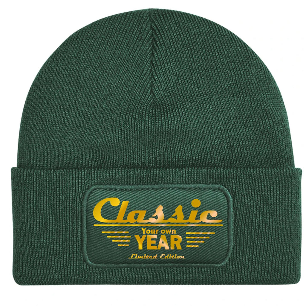 A customizable bottle green ribbed knit beanie hat featuring a rectangular embroidered patch on the front cuff with the text 'Classic Your own YEAR Limited Edition' in gold.