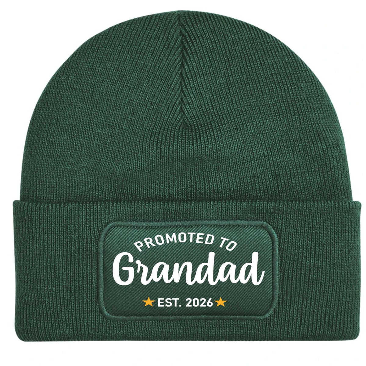 A dark green ribbed knit beanie hat with a cuffed brim, featuring a rectangular printed patch that reads 'PROMOTED TO Grandad EST. 2026' in white with yellow stars
