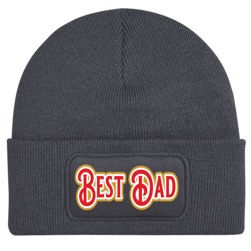 An charcoal greey ribbed knit beanie hat featuring a rectangular printed patch on the front cuff with the words 'BEST DAD' in red with a gold outline.
