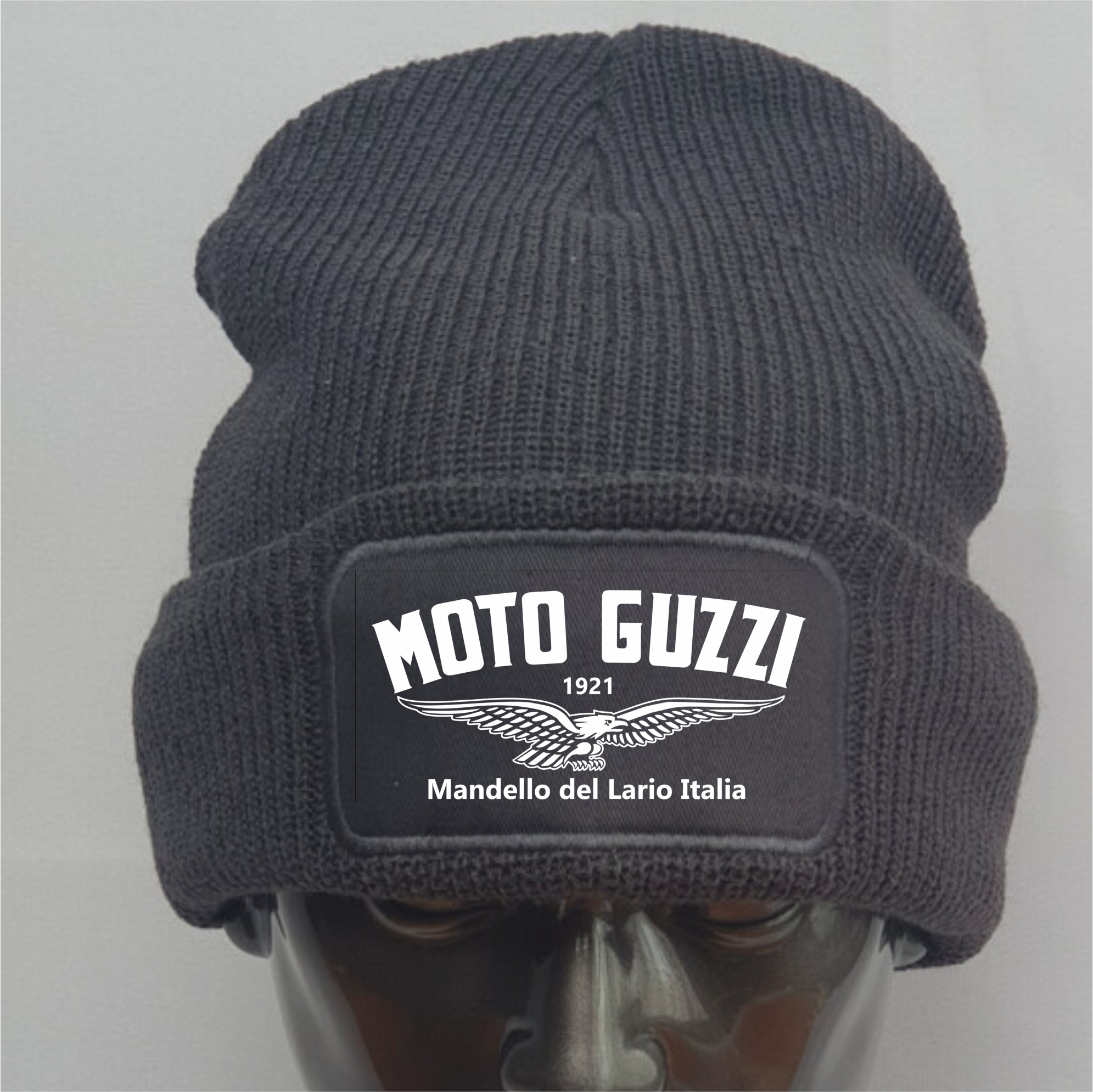 Dark gray knit beanie with Moto Guzzi logo on a mannequin head against a light gray background