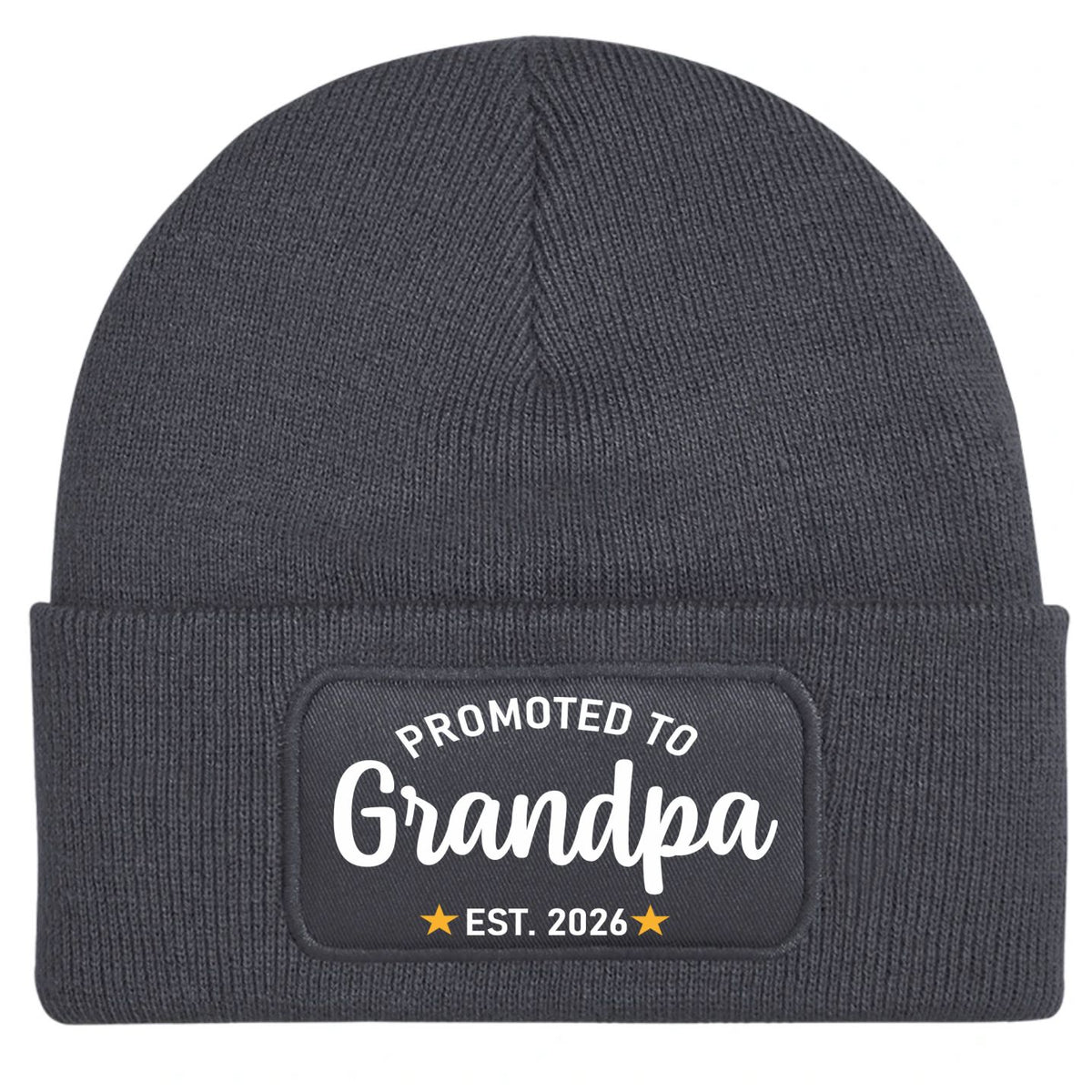 A dark gray ribbed knit beanie hat with a folded cuff, featuring a black rectangular patch on the front with the white text 'PROMOTED TO Grandpa' and 'EST. 2026' with small gold stars.