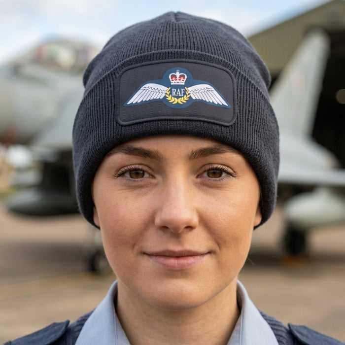 A dark gray ribbed knit beanie hat featuring a rectangular patch on the front cuff with the Royal Air Force wings emblem and 'RAF' text.