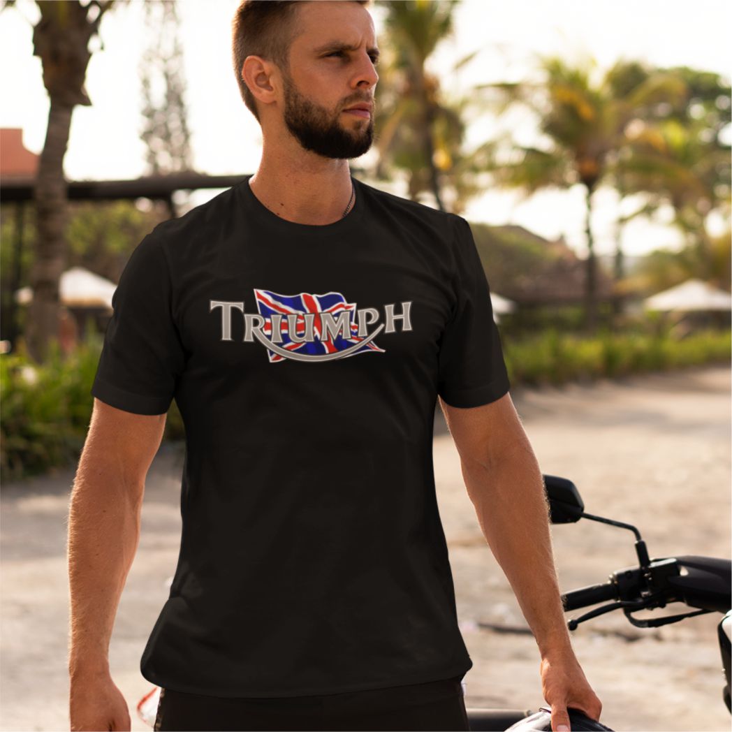 Man wearing a black Triumph t-shirt with a British flag design outdoors.