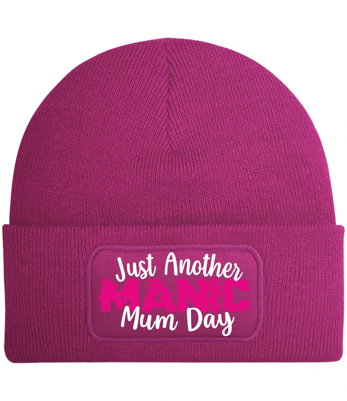 A magenta knit beanie with a cuffed brim, featuring a rectangular printed patch that reads 'Just Another MANIC Mum Day' in white and bright pink lettering.