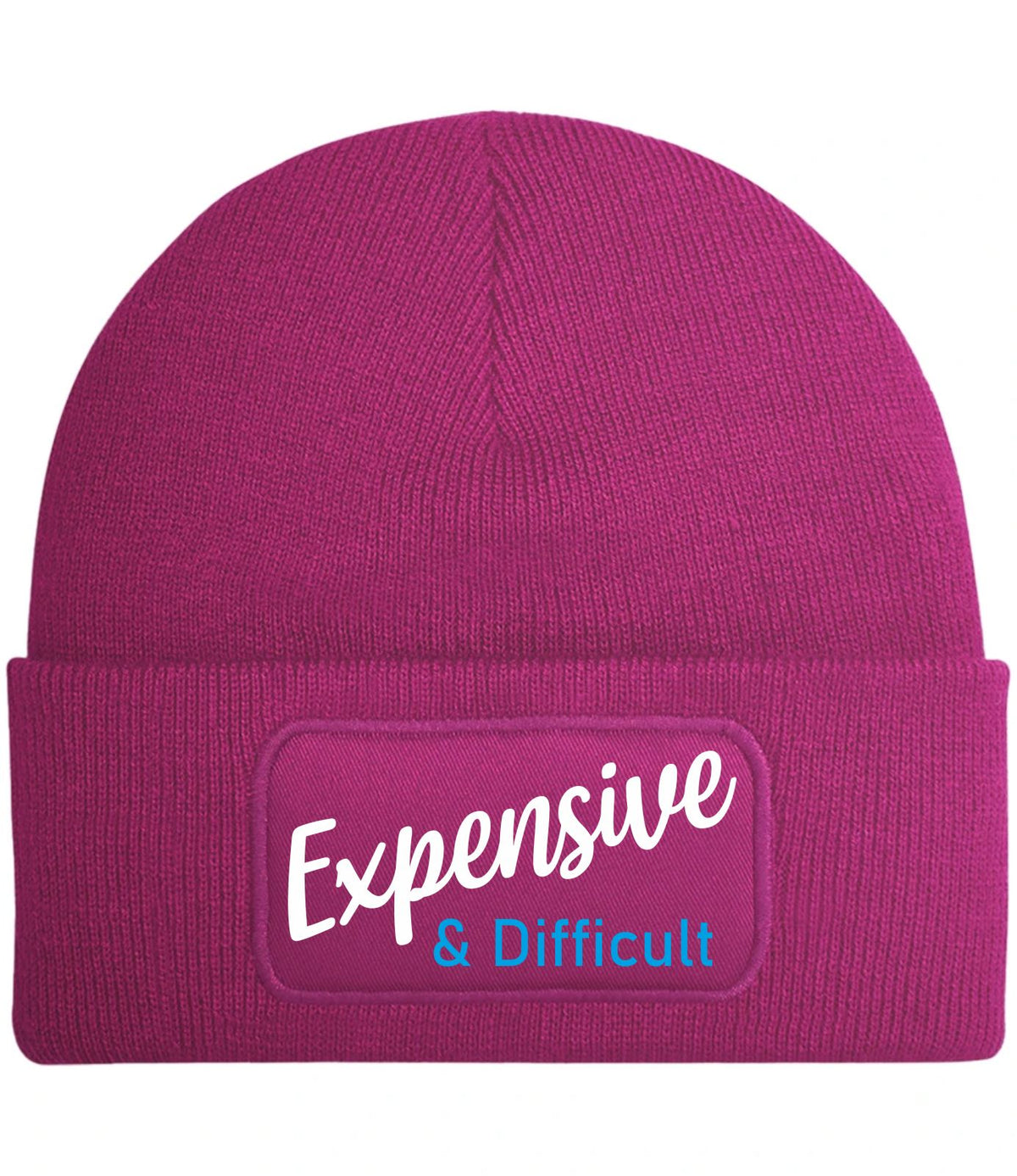 A magenta knit beanie hat with a folded cuff featuring a rectangular patch that reads 'Expensive & Difficult' in white and light blue text, shown on a plain white background.