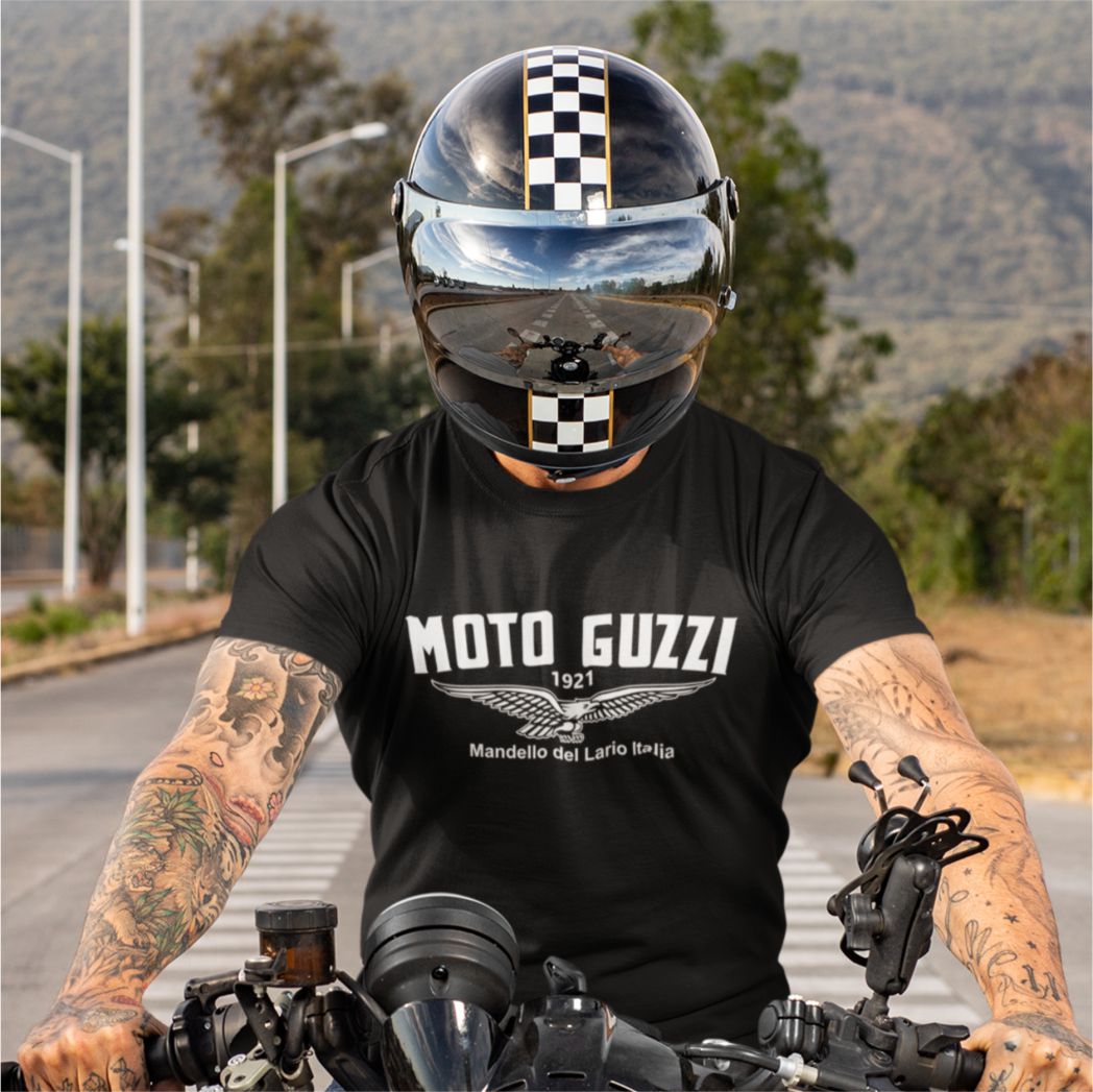 Person wearing a Moto Guzzi t-shirt and helmet on a motorcycle.