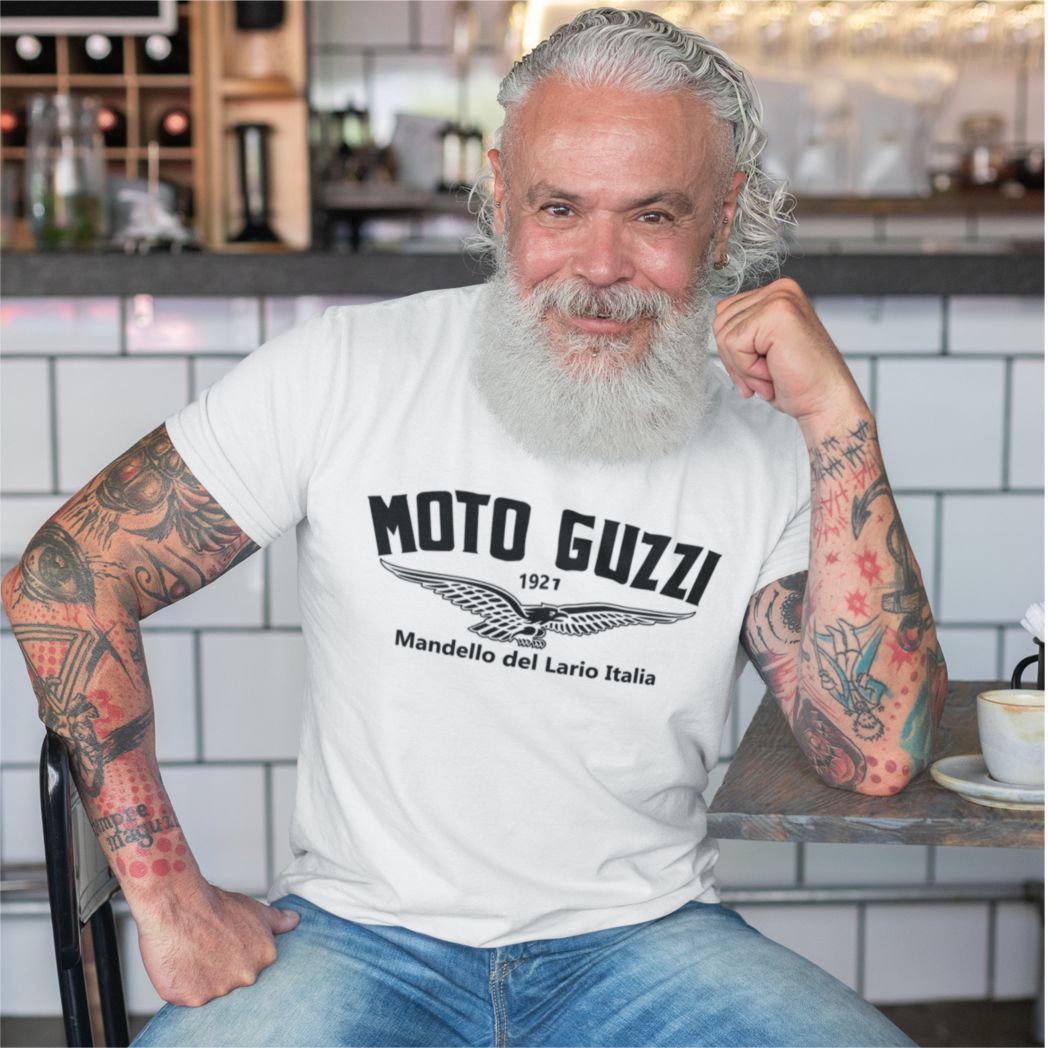 Man with tattoos wearing a Moto Guzzi t-shirt in a casual setting