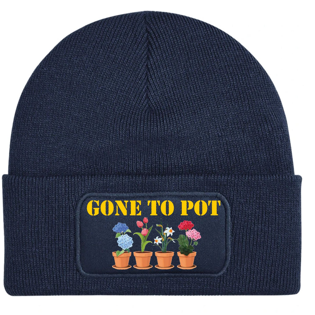 Annavy blue ribbed knit beanie with a folded cuff, featuring a printed patch that reads 'GONE TO POT' in yellow text above four colorful potted flowers.