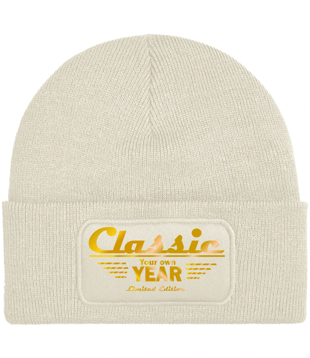 A customizableo atmeal ribbed knit beanie hat featuring a rectangular embroidered patch on the front cuff with the text 'Classic Your own YEAR Limited Edition' in gold.