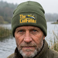 An olive green ribbed knit beanie hat featuring a rectangular printed patch on the front cuff with the text 'The CodFather' in yellow and a fish illustration.