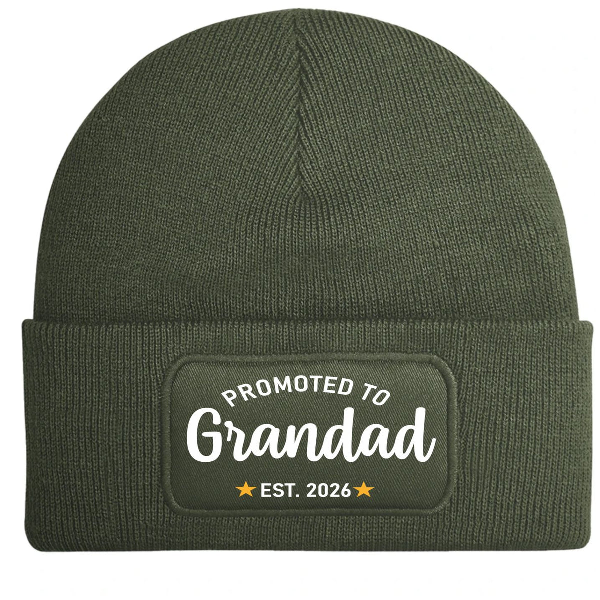 An olive green ribbed knit beanie hat with a folded cuff, featuring a rectangular printed patch that reads 'PROMOTED TO Grandad EST. 2026' in white and yellow.