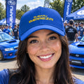A royal blue baseball cap featuring the yellow embroidered text 'SUBARU IMPREZA' on the front, set against a plain white background.