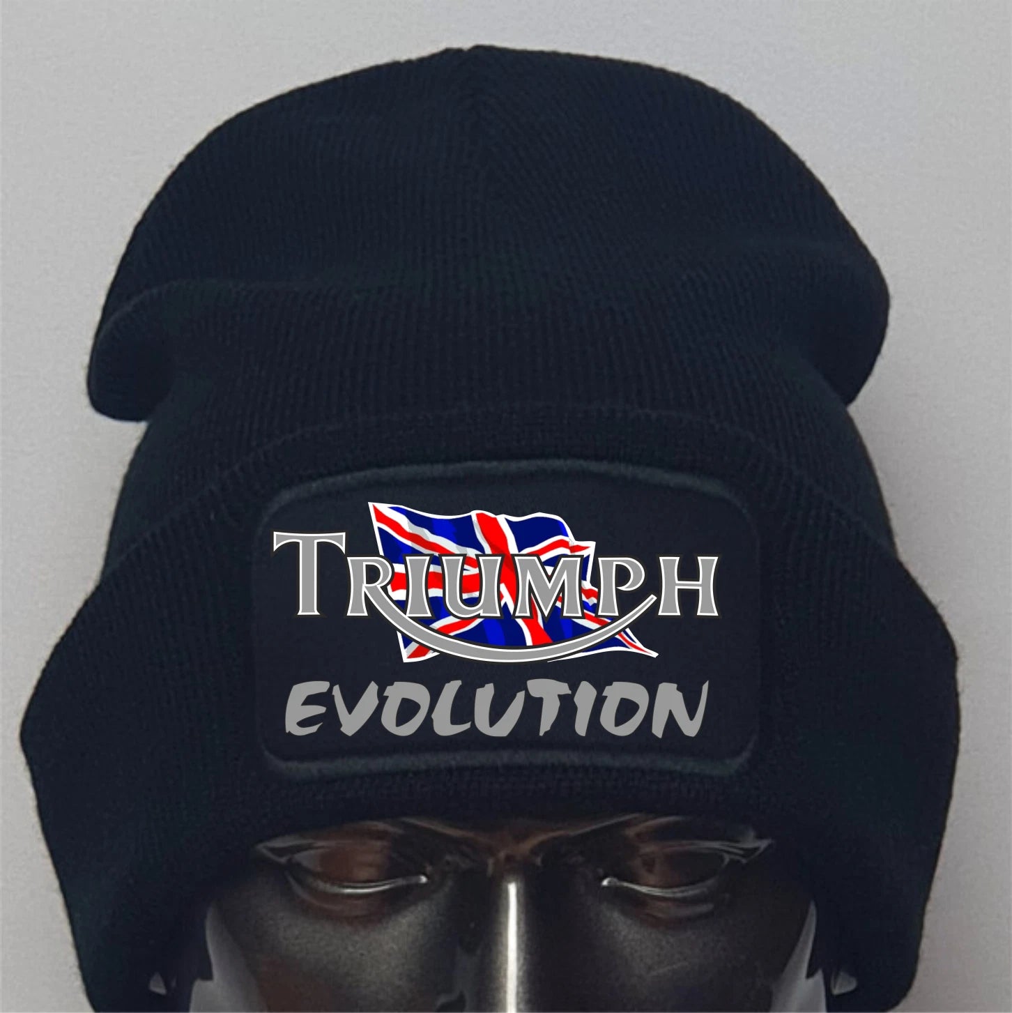 Black beanie with 'Triumph Evolution' logo on a mannequin head against a gray background
