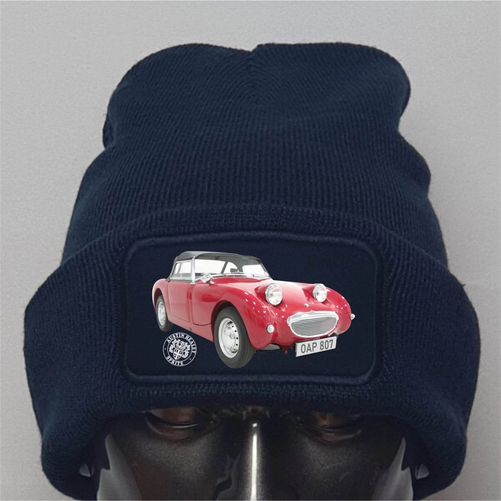 Navy blue beanie with a red car design on a gray background