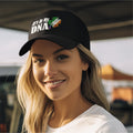 Woman wearing a black cap with 'It's in My DNA' text and clover design.