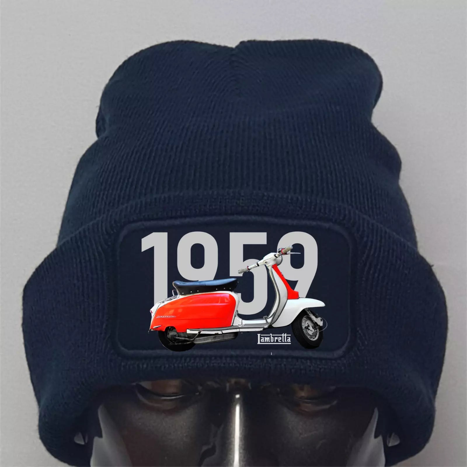 Navy blue beanie with a Vespa scooter patch featuring the year 1959 on a gray background