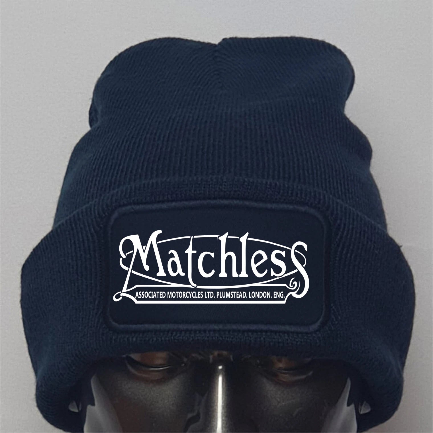 Navy blue beanie with 'Matchless' logo on a gray background