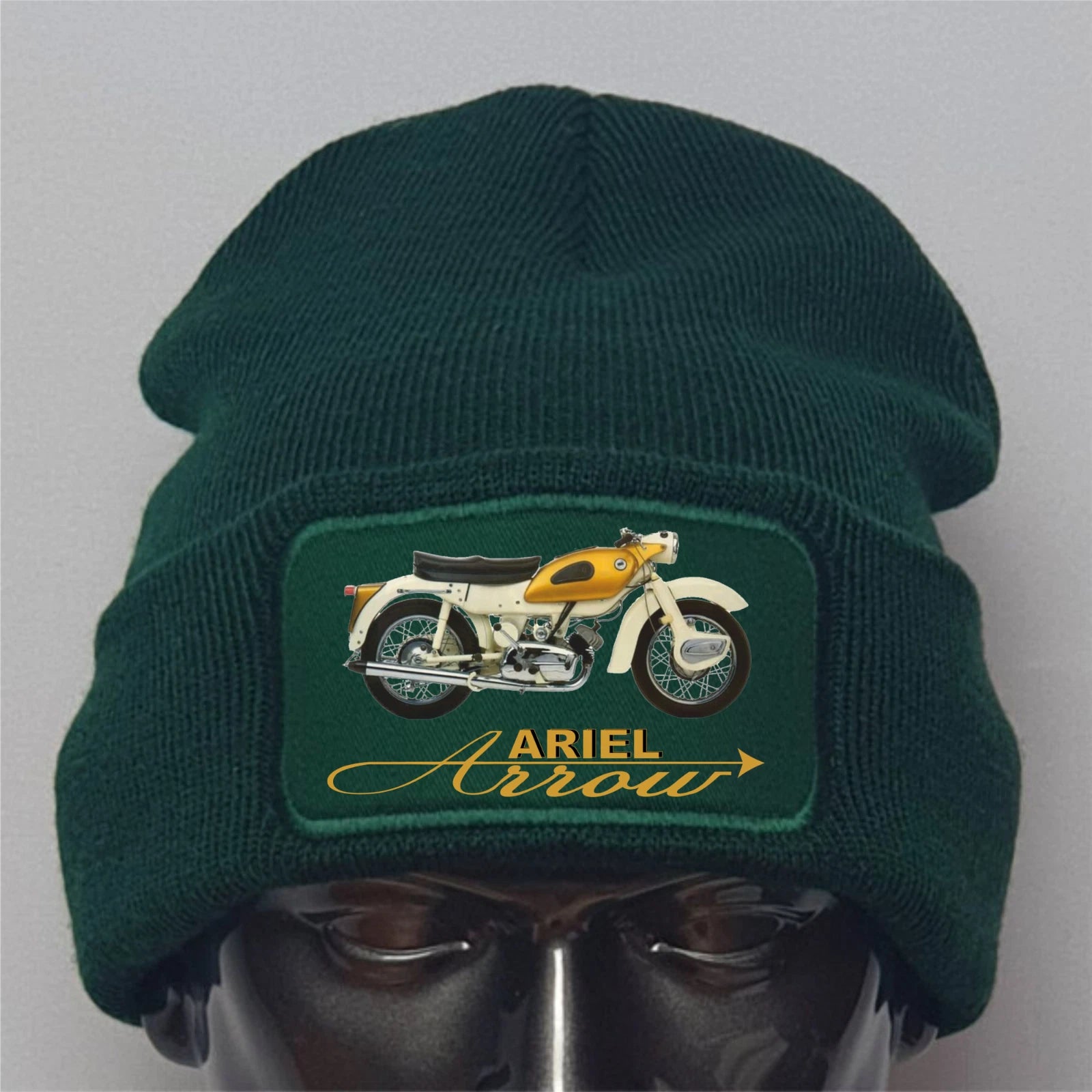 Green beanie with Ariel Arrow motorcycle patch on a gray background