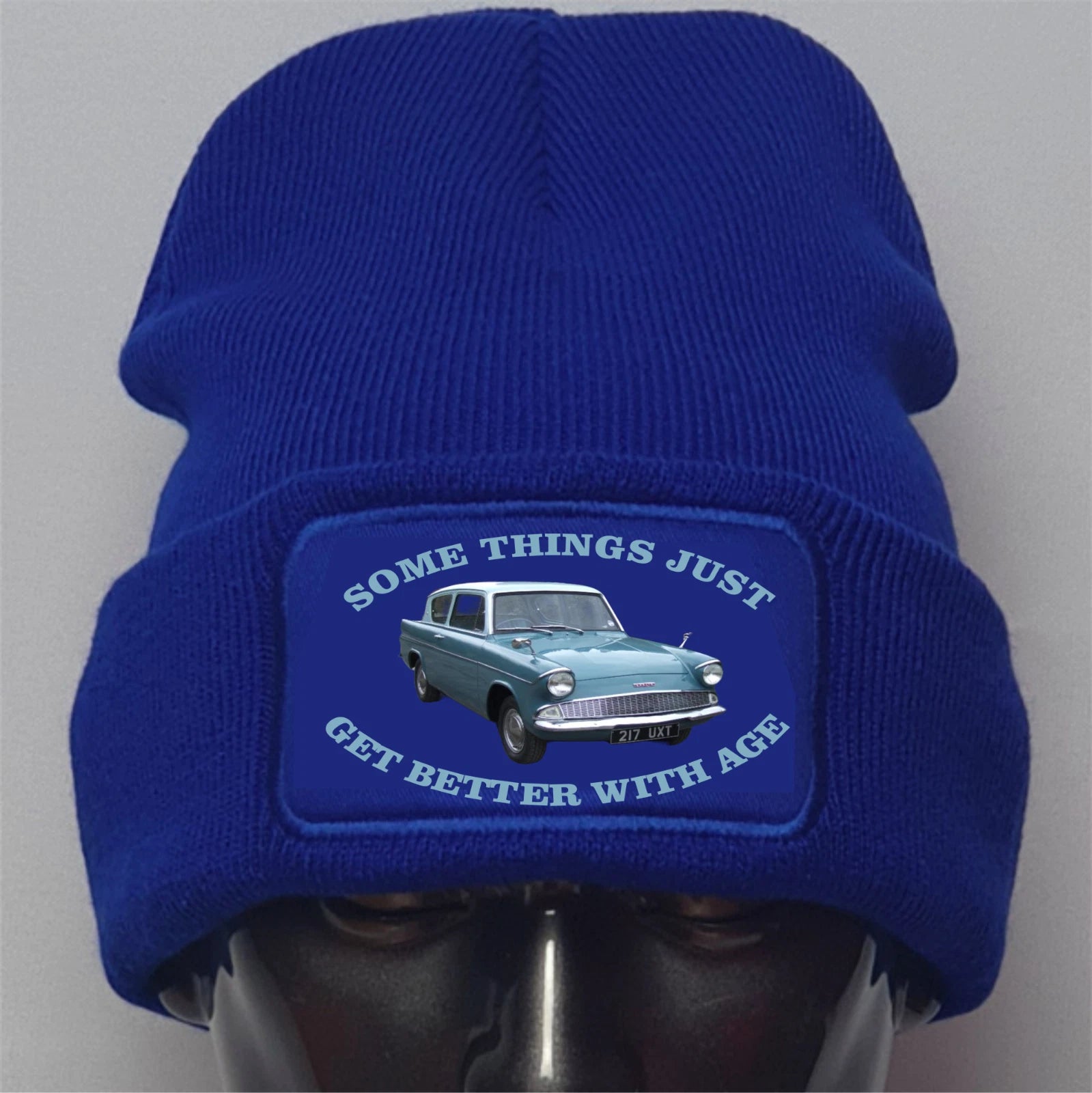 Blue beanie with a patch featuring a car and text on a gray background
