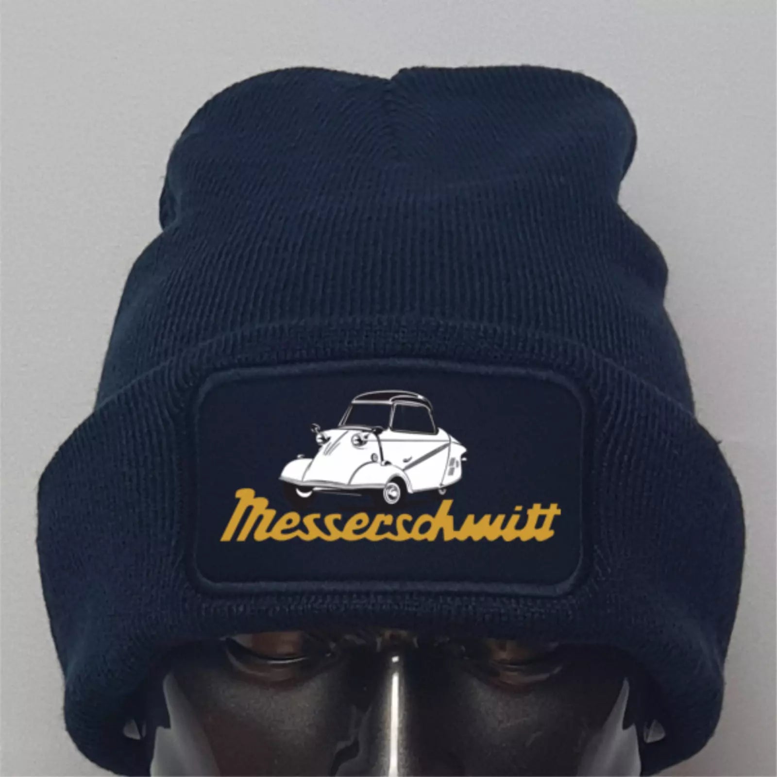 Navy blue beanie with Messerschmitt logo on a gray background