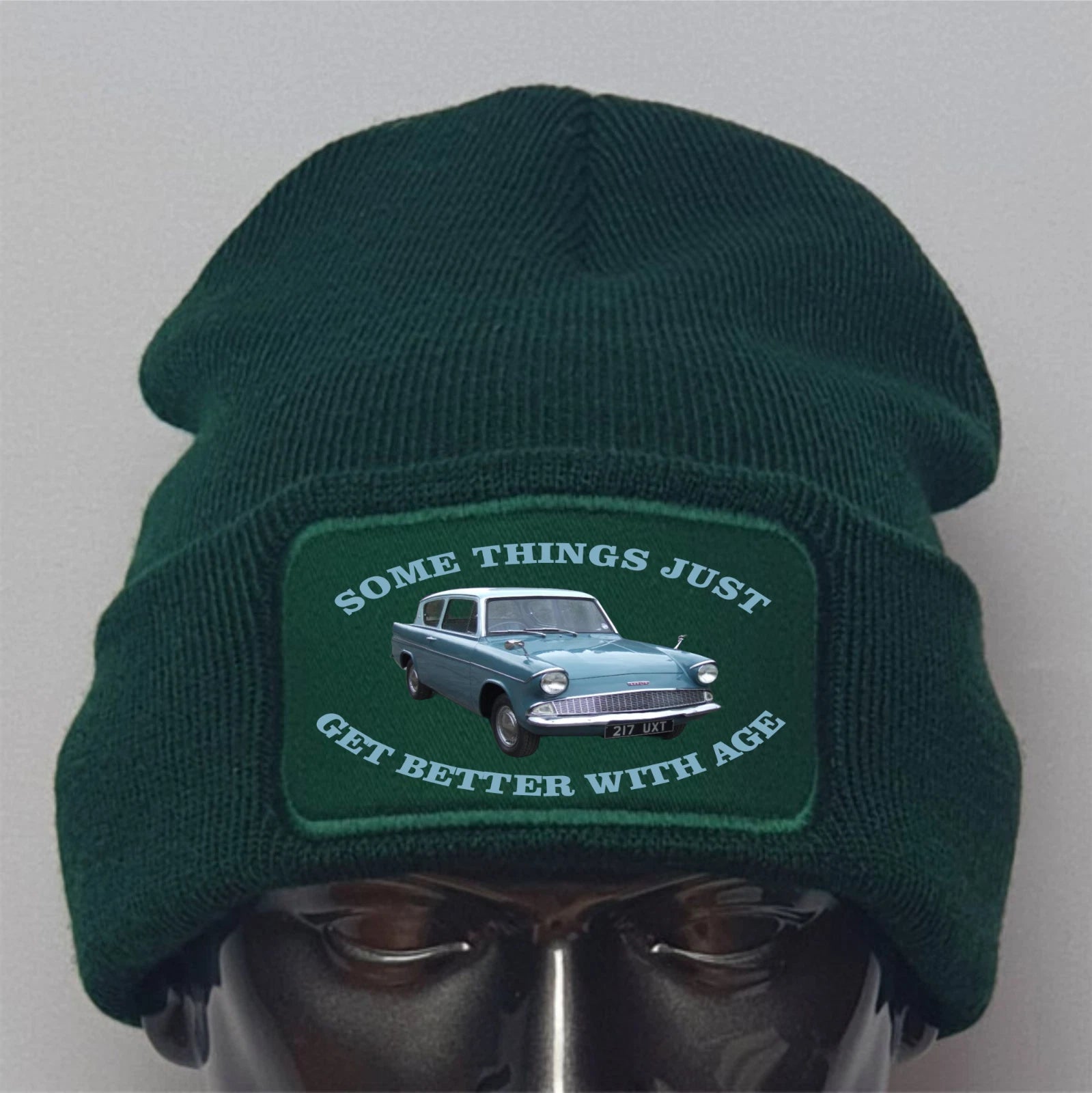 Green beanie with embroidered patch featuring a car and text on a gray background