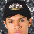 Person wearing a black cap with 'Royal Navy Veteran' embroidery against a metallic background