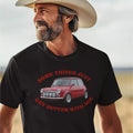 Man wearing a black t-shirt with a red car graphic and text in a desert setting