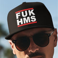 Person wearing a black cap with 'FUK HMS' text, sunglasses, against a blurred background