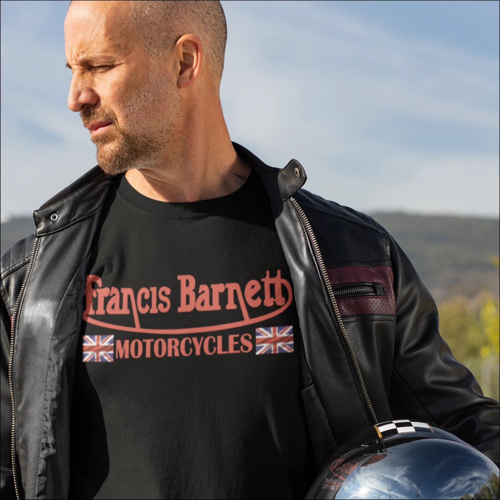 Man wearing a black t-shirt with 'Francis Barnett Motorcycles' text and logo, standing outdoors.