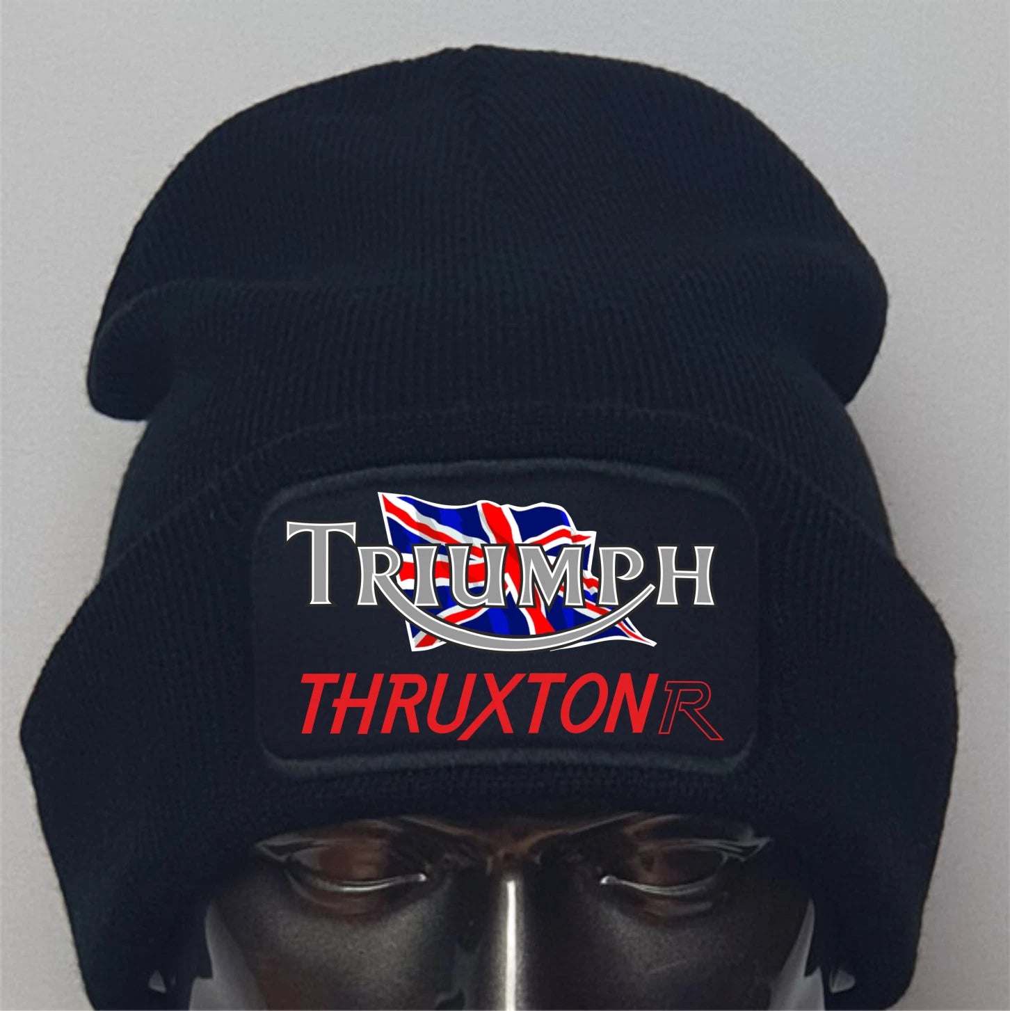 Black beanie with Triumph Thruxton logo on a mannequin head against a gray background