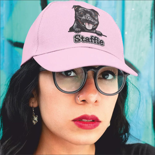 Person wearing a pink cap with a dog illustration and text, against a blue background