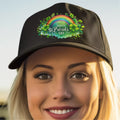 Black cap with St. Patrick's Day design featuring a rainbow and shamrocks, worn by a person.