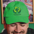 Person wearing a green St. Patrick's Day cap with a four-leaf clover design.