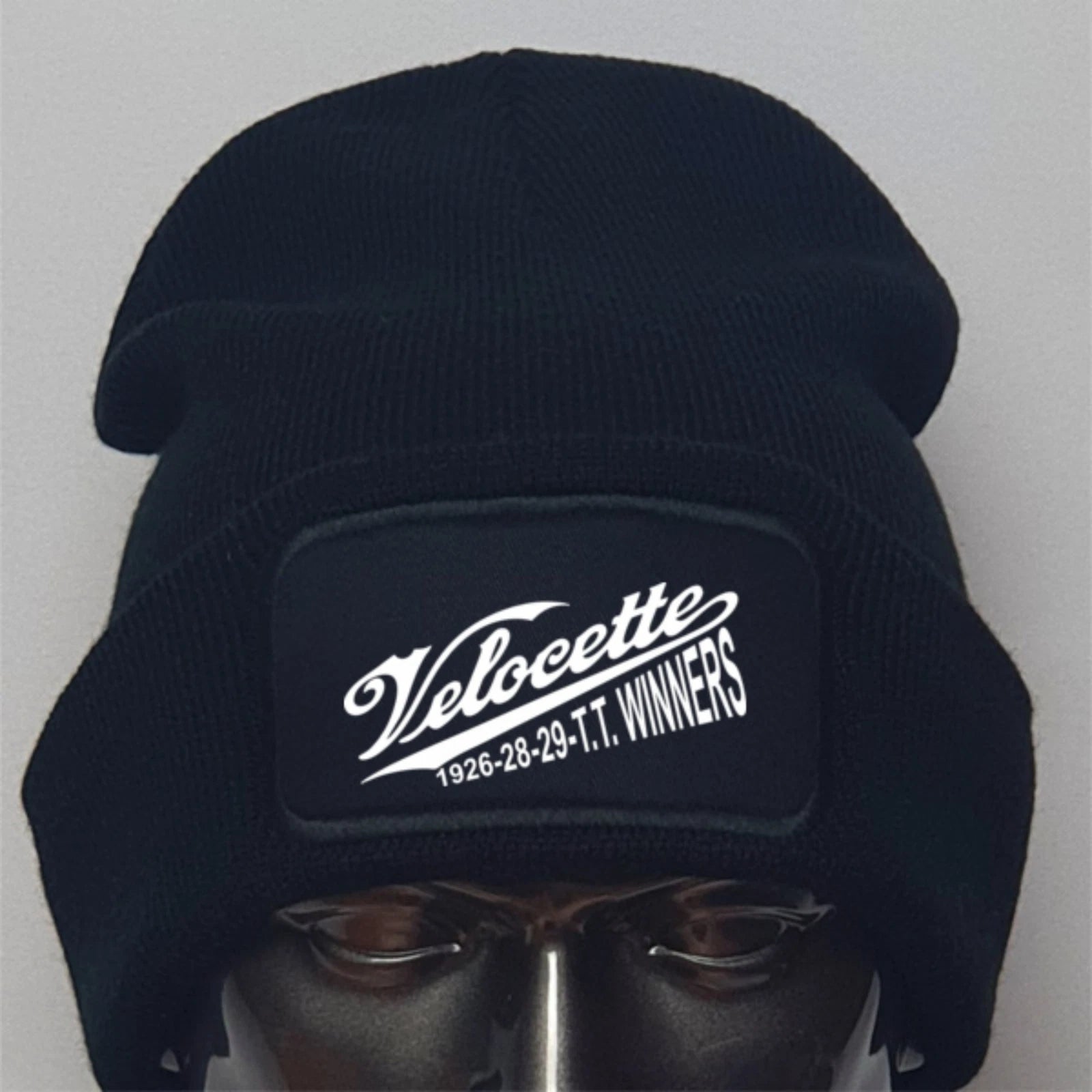 Black beanie with Velocette logo on a mannequin head against a gray background