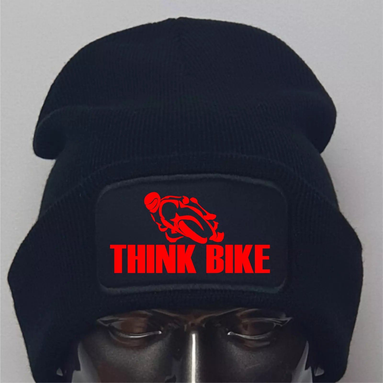 Black beanie with red 'THINK BIKE' logo on a mannequin head against a gray background