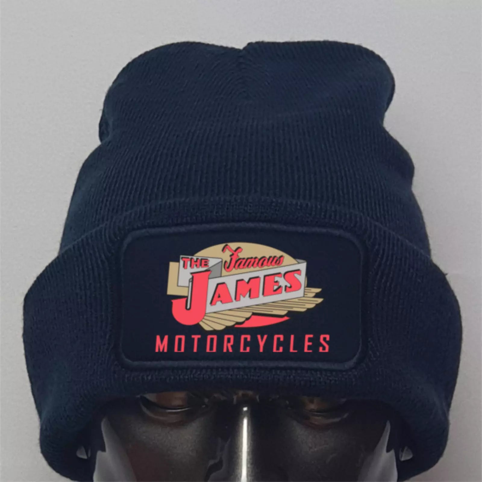 Navy blue beanie with 'The Famous James Motorcycles' logo on a gray background